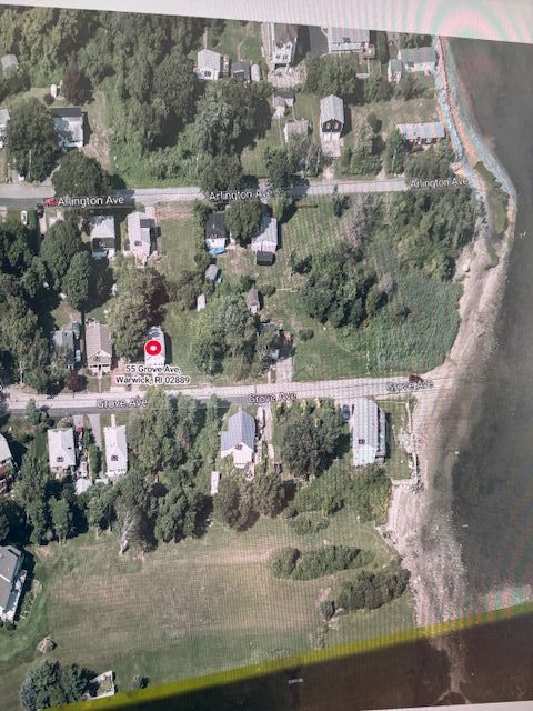 Property is the empty lot to the right of the house with the red dot